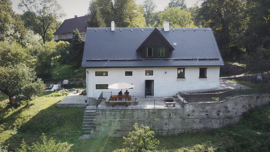 Chalupa shora, kamenná terasa se slunečníkem, opěrná zeď a zahrada